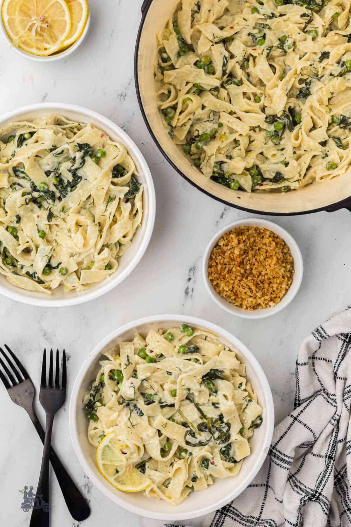 The Mediterranean pasta dish is served in white bowls, ready to have the Panko crumbs sprinkled on top. 