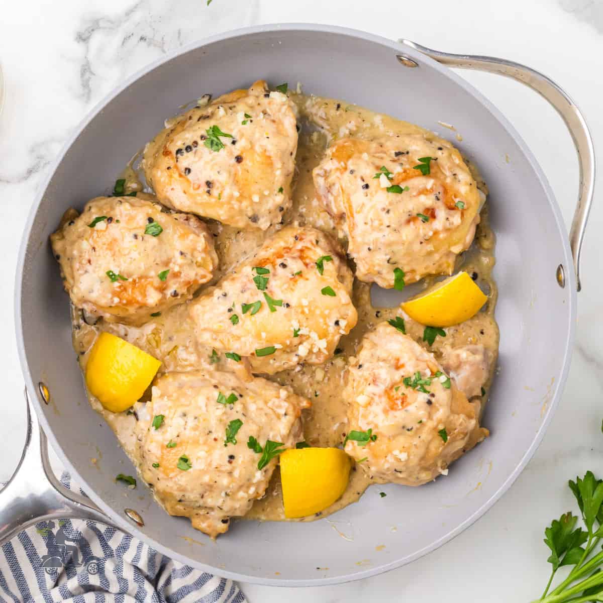 A skillet filled with chicken thighs prepared in a cacio e pepe style.