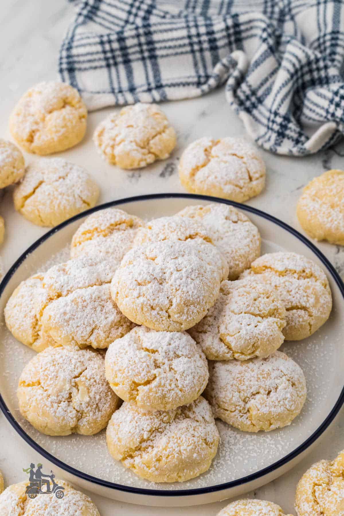 St. Louis-style cream cheese butter cookies made with yellow cake mix, sprinkled with powdered sugar, and served on a plate.