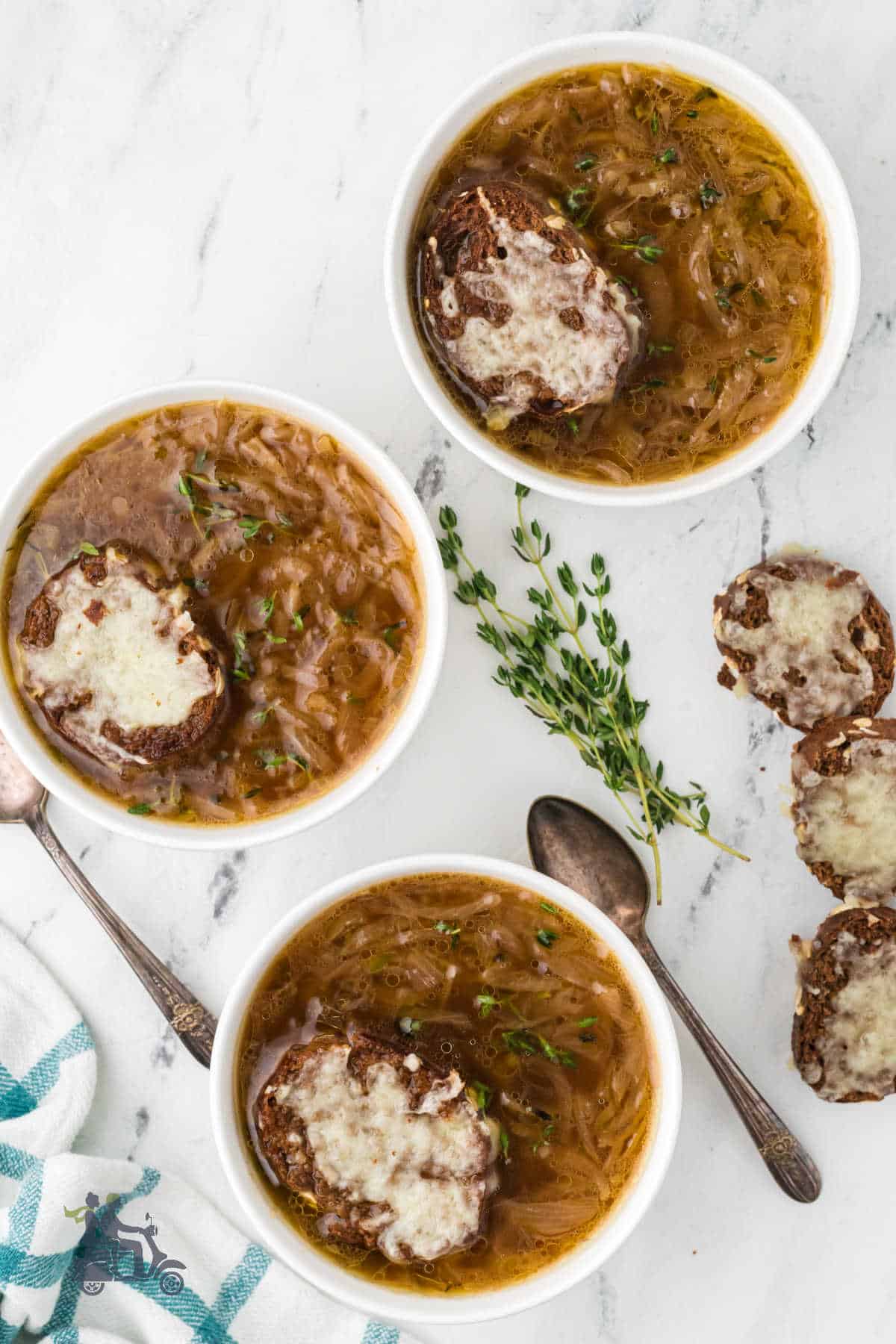 Easy French Onion Soup made in a crockpot served in white soup bowls with Gruyère toast on top. 