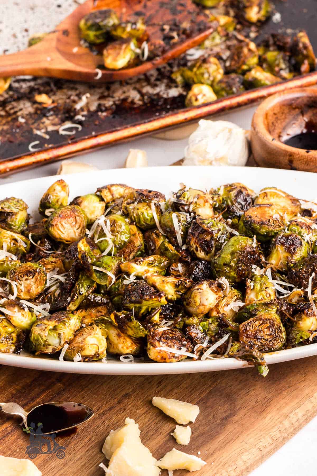 Italian-inspired Parmesan Brussels Sprouts with Garlic and balsamic glaze on a vegetable platter.
