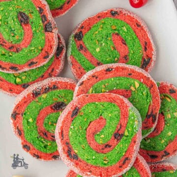 Cherry Pistachio Christmas spiral Cookies on a white tray.