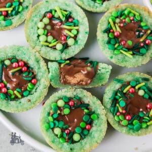 Sugar cookie cups filled with Reese's cups and decorated to look like a Christmas wreath.