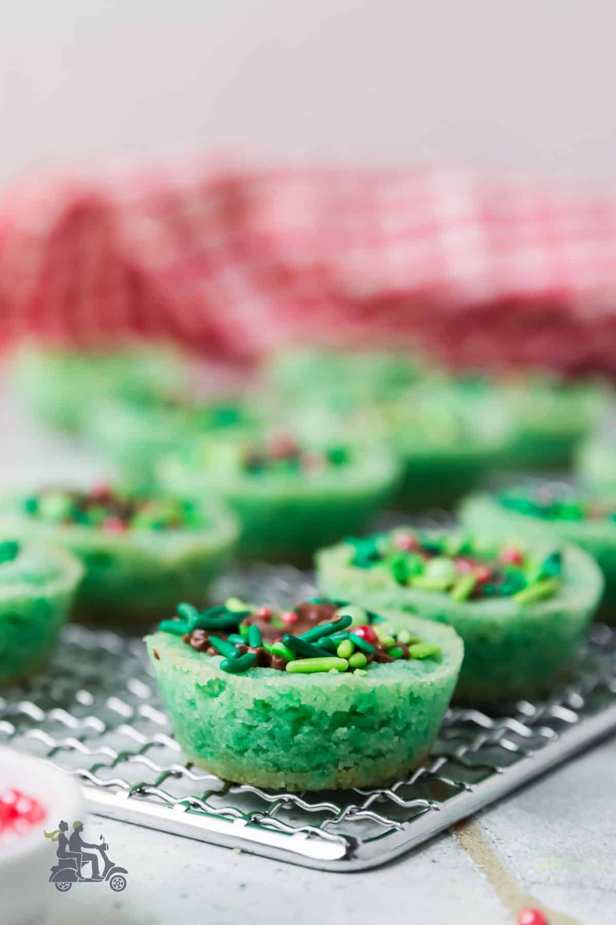 Sugar cookie cups filled with a peanut butter cup cooling on a wire rack. 