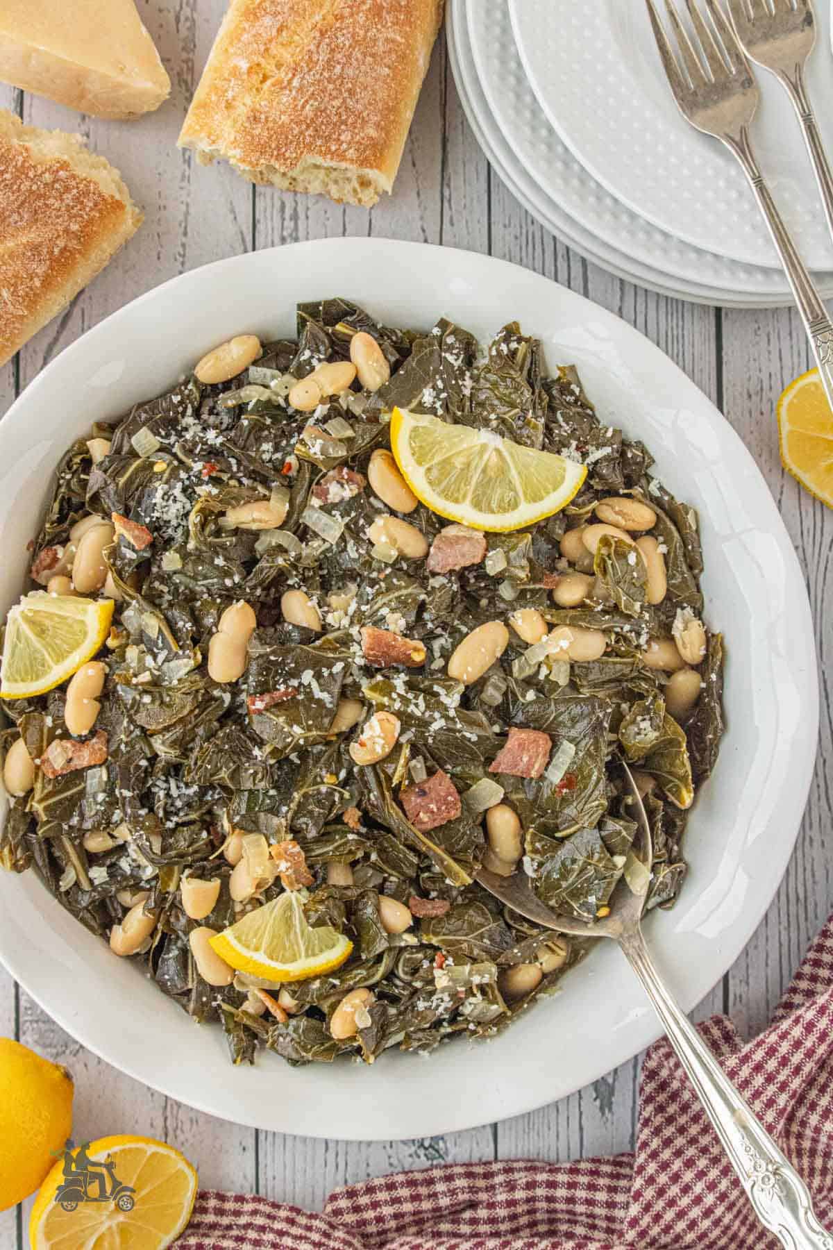 A serving bowl filled with Collard Greens with Pancetta and Cannellini Beans, with a serving spoon placed in the bowl.