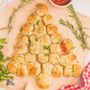 Cheese-stuffed rolls in the shape of a Christmas tree on a cutting board.