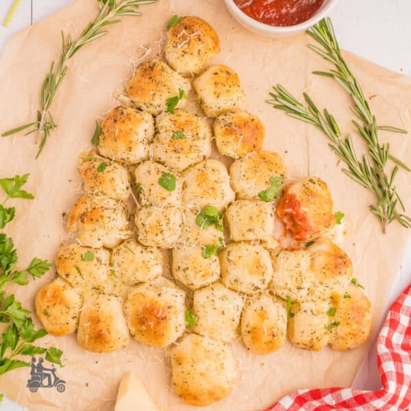 Cheese-stuffed rolls in the shape of a Christmas tree on a cutting board.