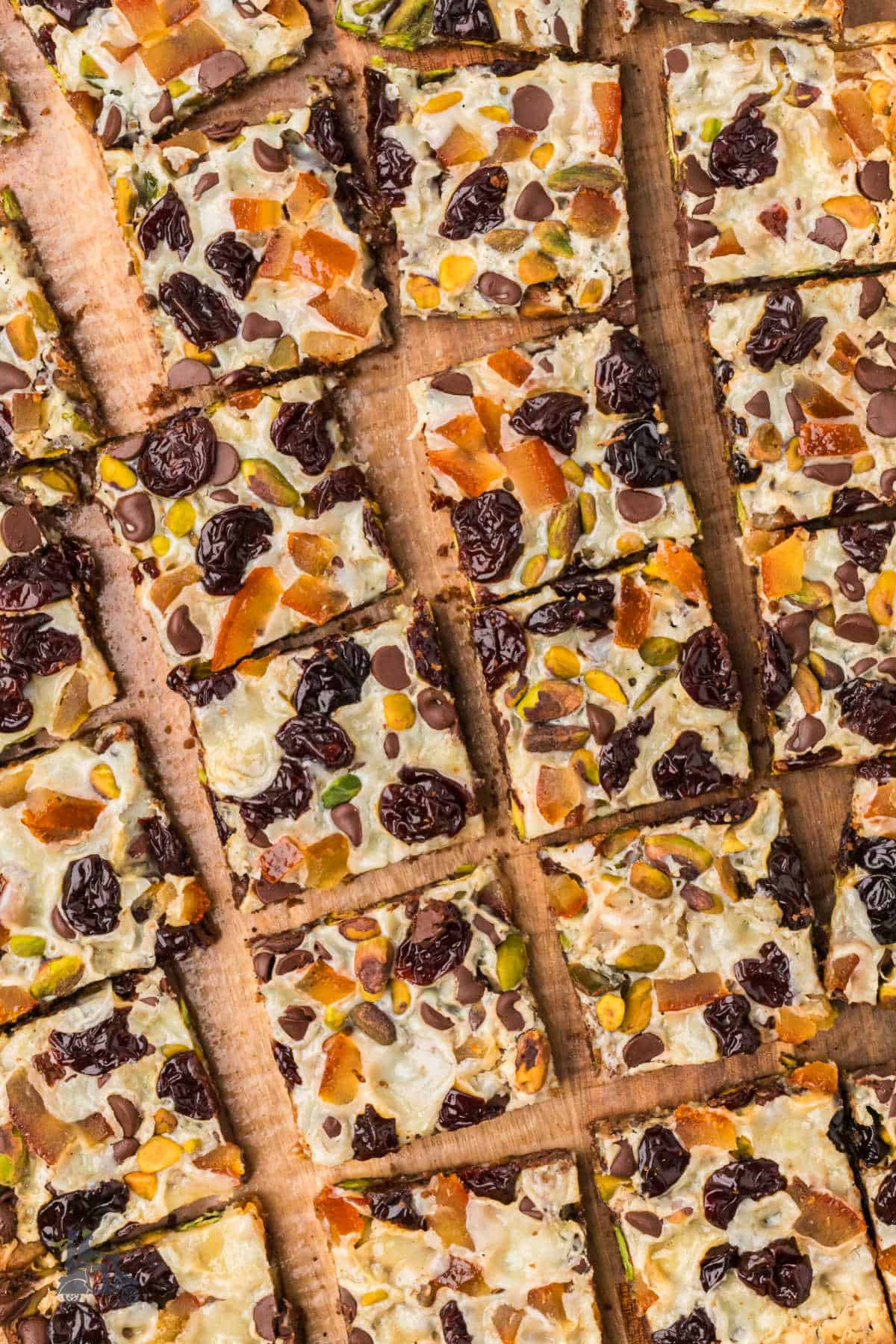 Overhead view of sliced Holiday Magic Bars with espresso crumb crust and colorful toppings. 