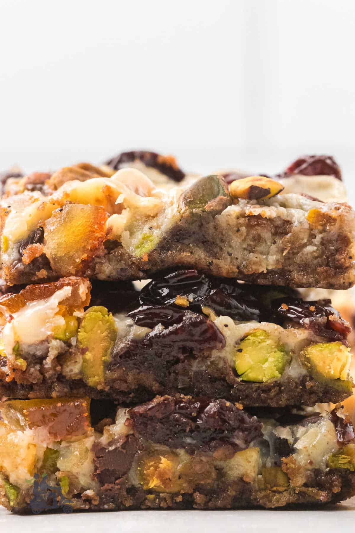 Stack of holiday cookie bars with a gingersnap crust and festive fruit-and-nut topping. 
