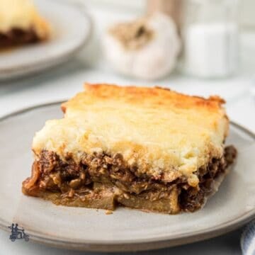 A square of Greek Moussaka casserole on a stonewear plate.