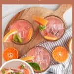 Overhead view of three glasses filled with tangerine basil cocktail drink with a wedge of pink grapefruit and a spring of basil.