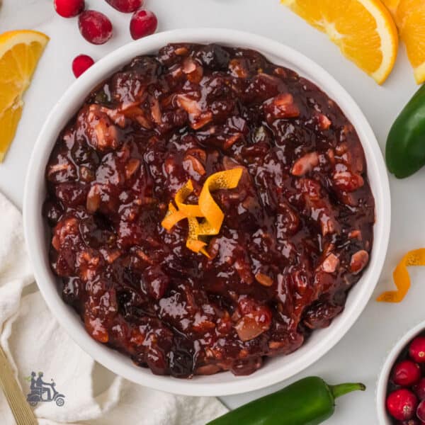 A white serving bowl holds the Cranberry Orange Relish recipe with dried cherries and jalapeño pepper.