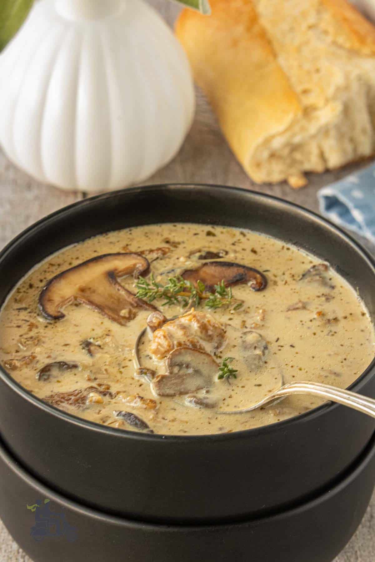 Spoon dipping into creamy mushroom sausage soup.