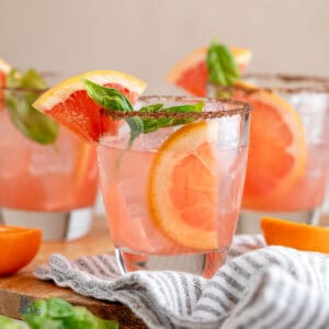 Three short tumblers filled with the Tangerine Basil Grapefruit cocktail.