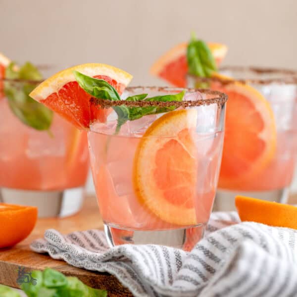Three short tumblers filled with the Tangerine Basil Grapefruit cocktail.