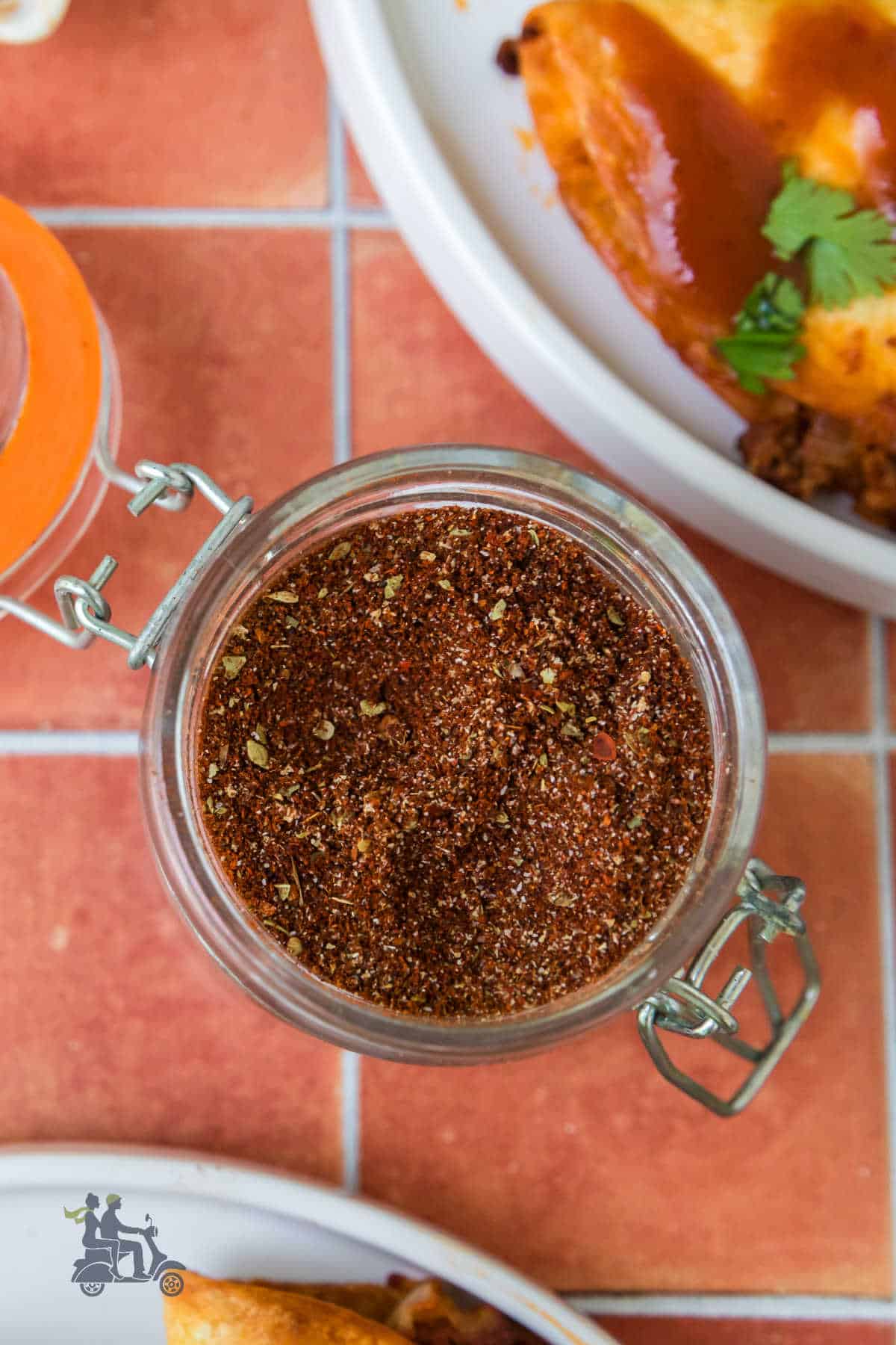 An overhead view of the Beef Taco Seasoning mix next to a plate of beef tacos. 
