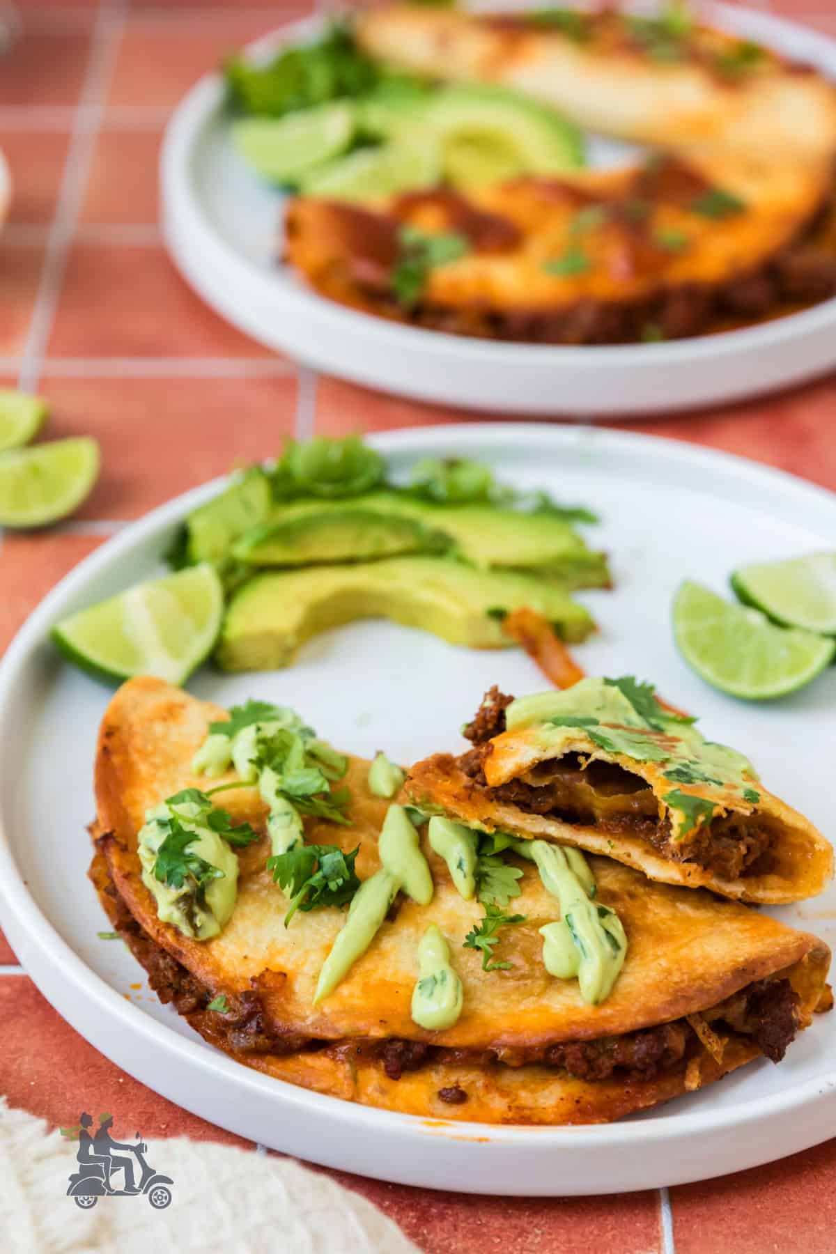 Side view of the beef tacos with a drizzle of cilantro cream sauce on top.