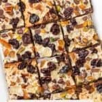 Overhead view of sliced Holiday Magic Bars with espresso crumb crust and colorful fruit in the bars.