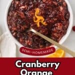 Spicy cranberry relish made with orange zest and dried cherries in a white serving bowl with a long-handled spoon.