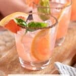 A long Pinterest pin featuring three glasses filled with the grapefruit cocktail with basil syrup.