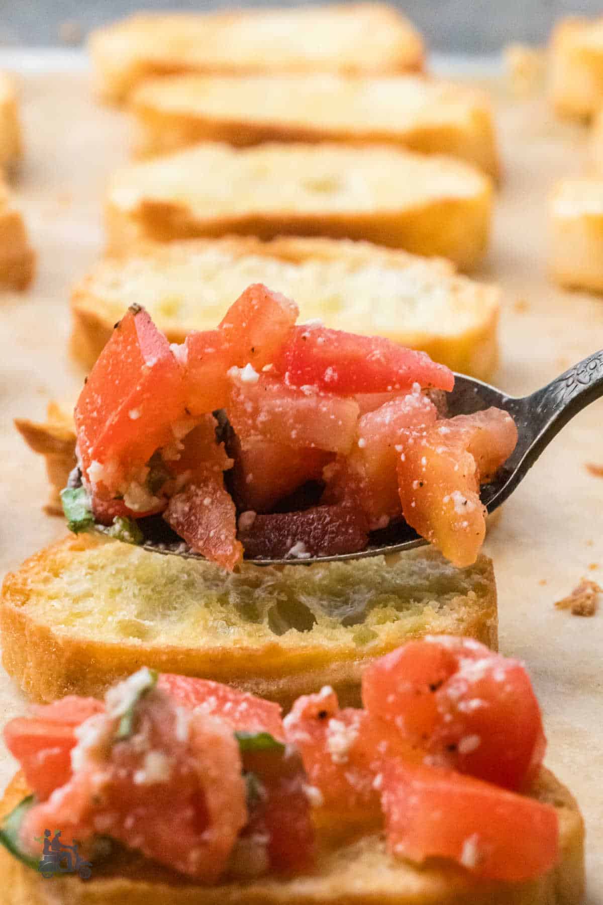 Closeup of a spoon holding a scoop of the bruschetta mix.