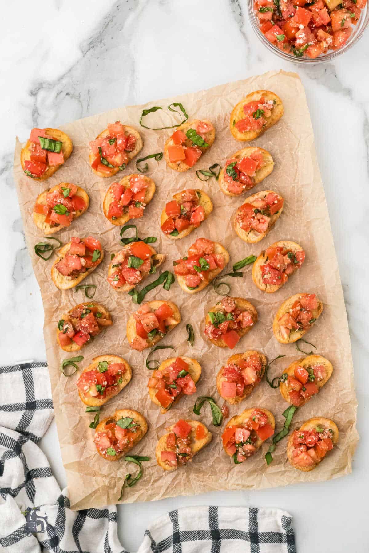 Italian-style bruschetta appetizer on a sheet of brown parchment paper.