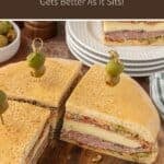 Muffuletta sanwich sliced into wedges on a wooden board.