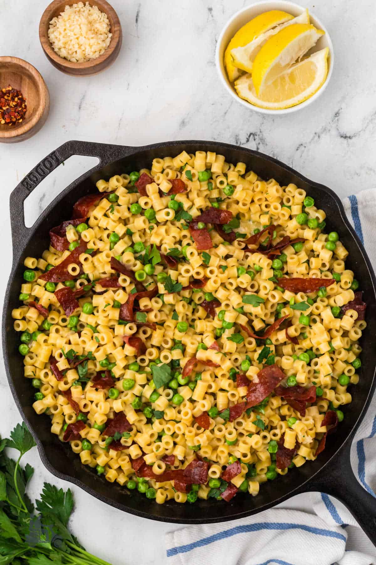 One-pan ditalini pasta with peas and parmesan in a black skillet. 