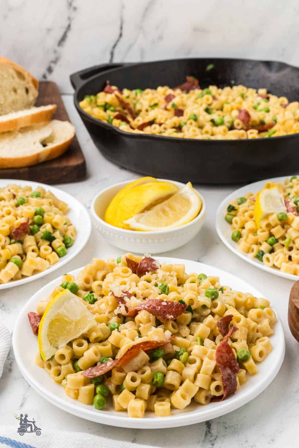 One-pot ditalini and peas are ready to serve with lemon wedges.