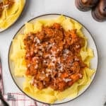 A plate filled with pappardelle pasta and served with pork Ragù in bianco.