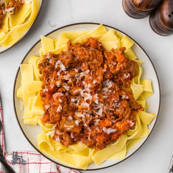 A plate filled with pappardelle pasta and served with pork Ragù in bianco.