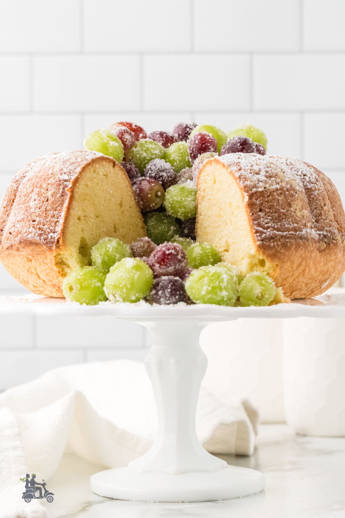 Irish Butter Cake with sugared grape garnish on a white cake stand. 