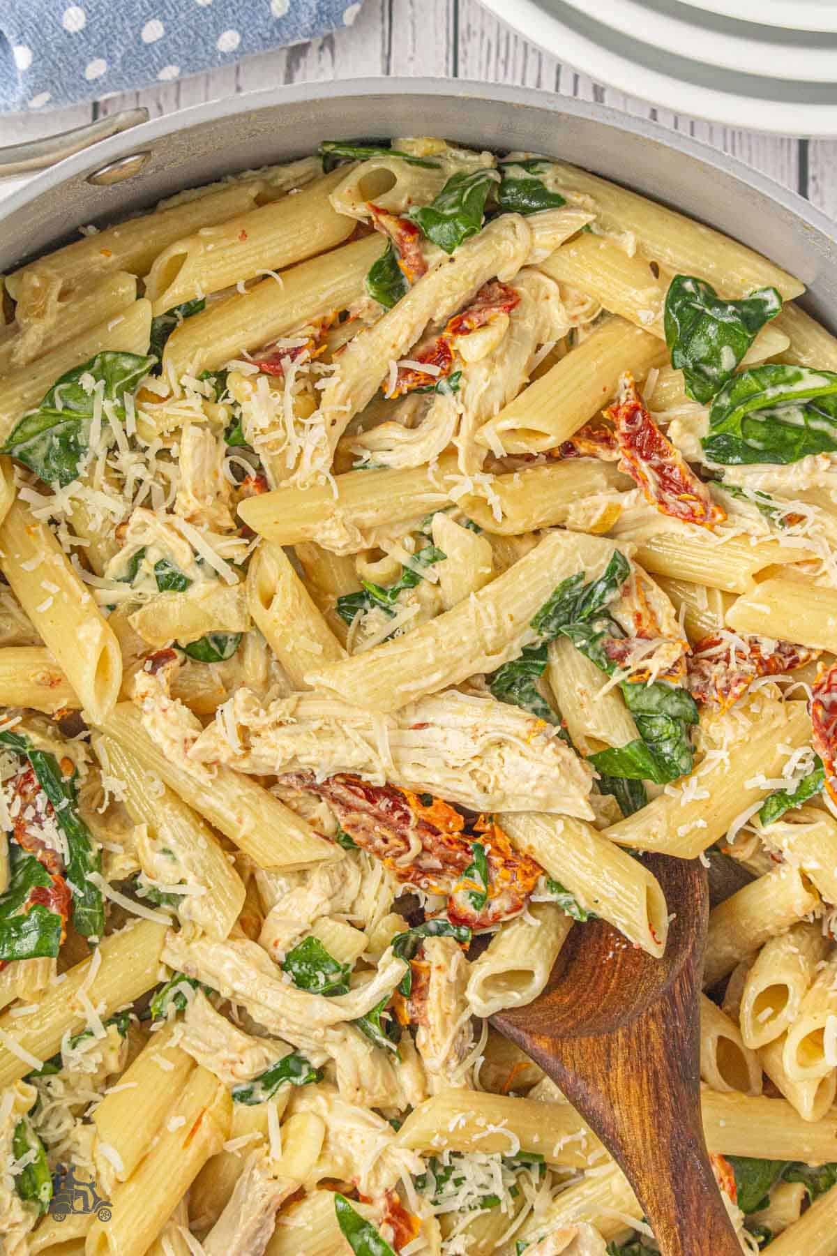 Family-style creamy chicken pasta with spinach and sun-dried tomatoes.