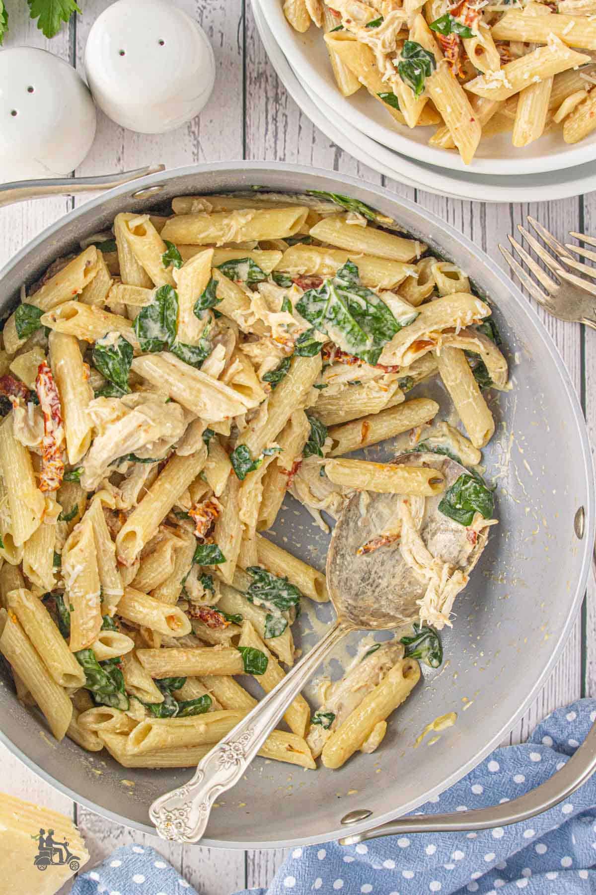 Wilted fresh spinach mixed in with the penne pasta, sun-dried tomatoes, and shredded rotisserie chicken.