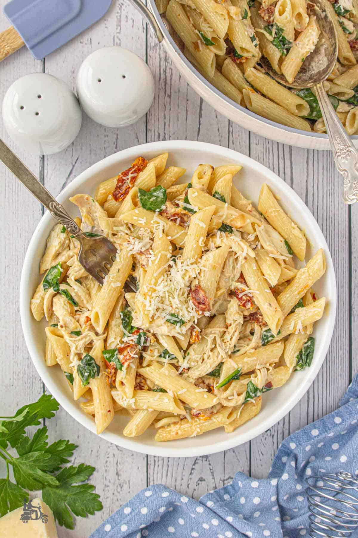 Shredded parmesan cheese sprinkled over creamy spinach and rotisserie chicken pasta.