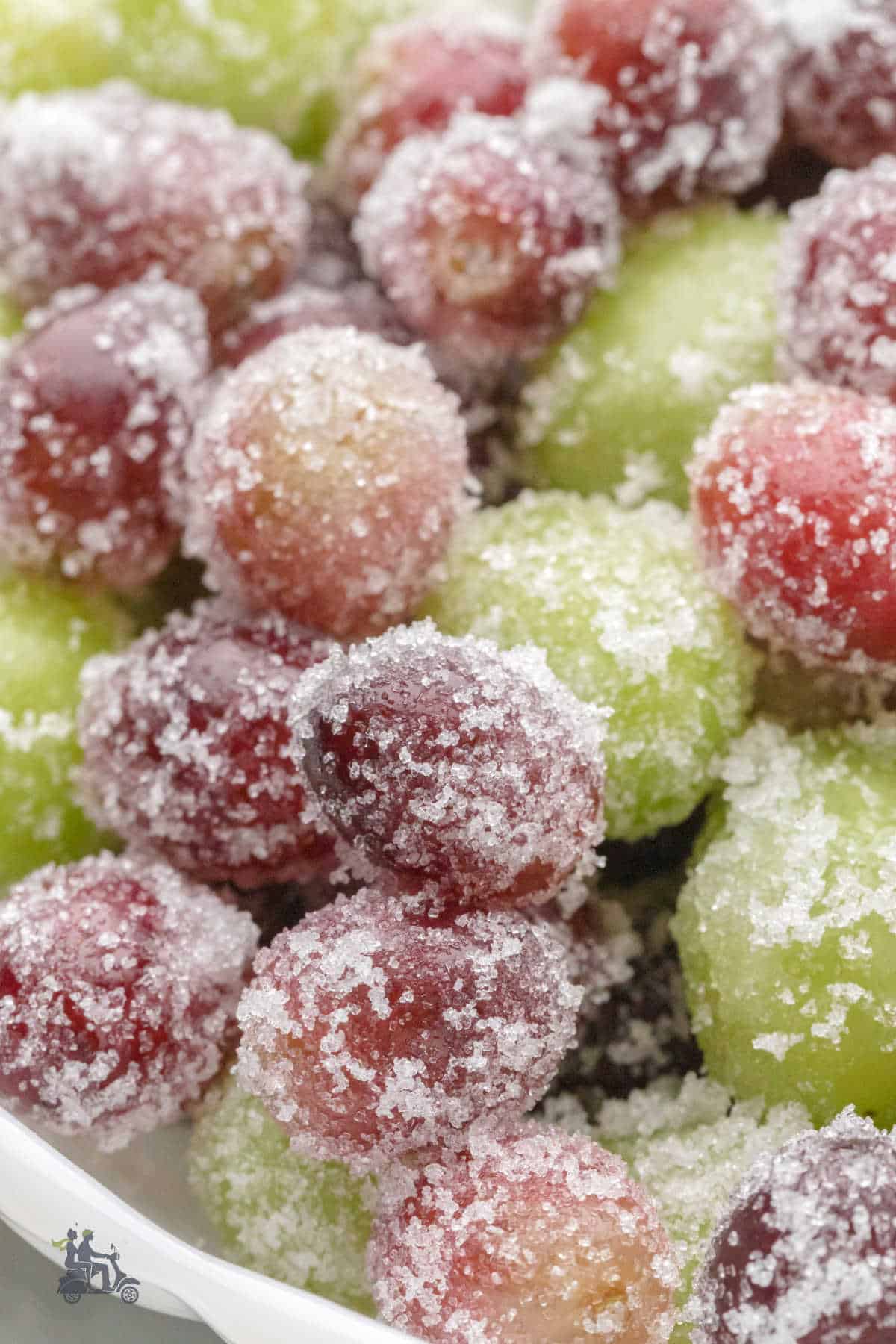 Close-up view of a bowl filled with the sugared prosecco grapes that are frosted with white baker's sugar.