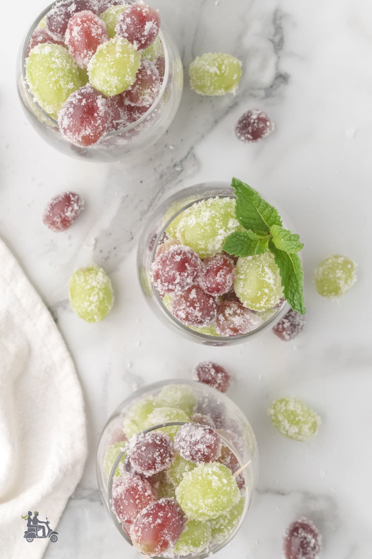 Dessert glasses filled with the sugar-frosted grapes and garnished with mint leaves.