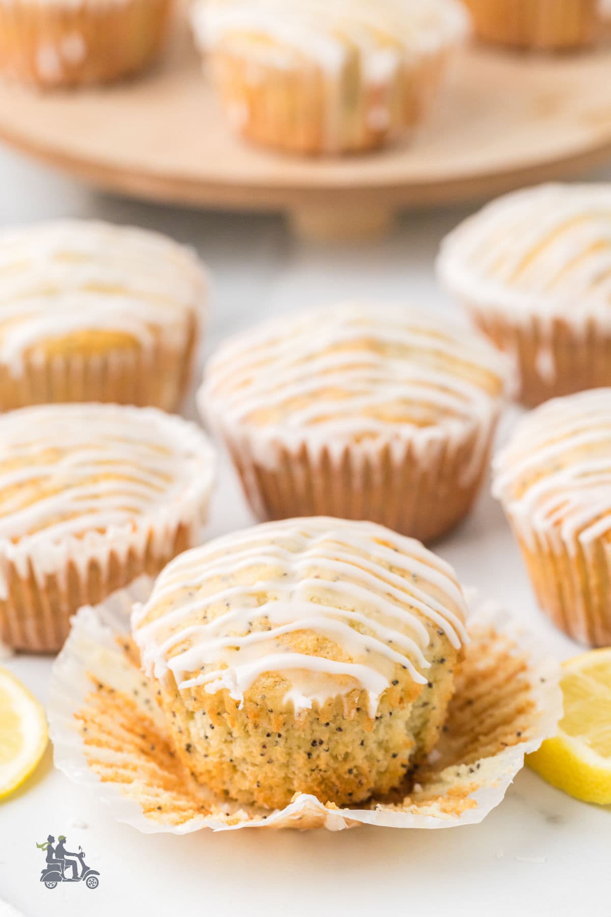 A spring poppy seed muffin with lemon flavor has the muffin paper peeled from it, showing the inside.