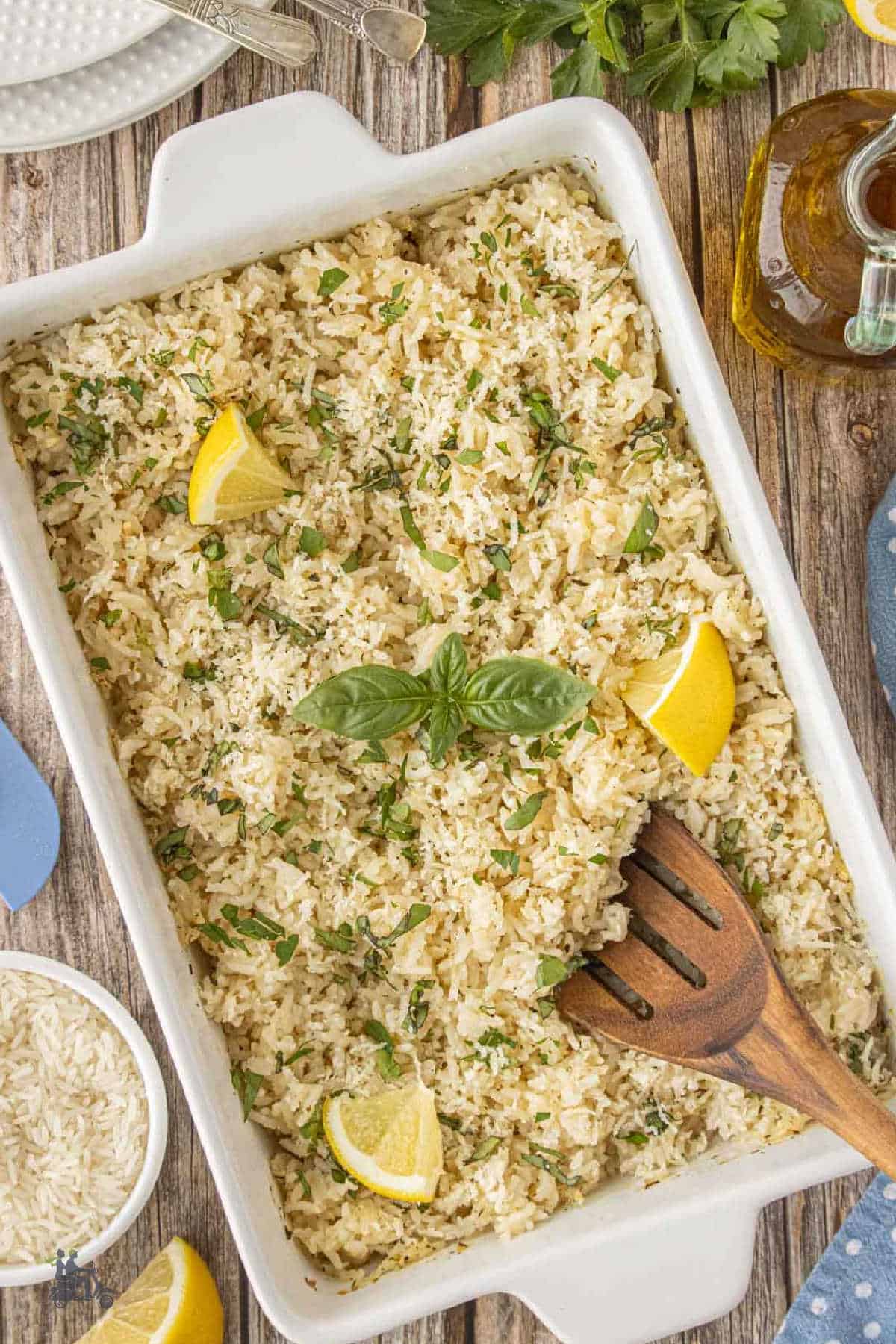 Oven-baked rice in a white serving dish finished with lemon and fresh herbs.