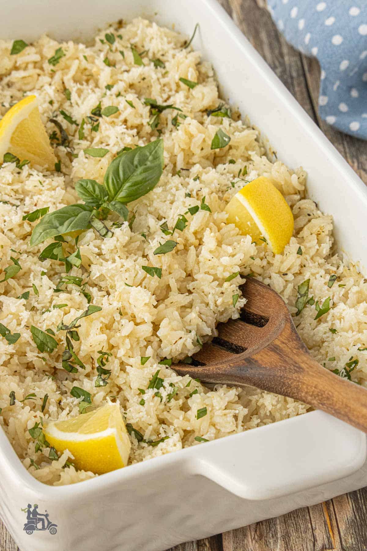 Wooden serving spoon scooping up the fluffy, herb-mixed flavored rice.