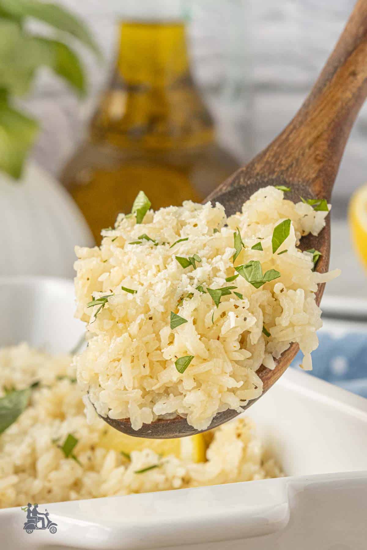 Closeup of a wooden spoon holding a hefty scoop of fluffy oven-baked rice.