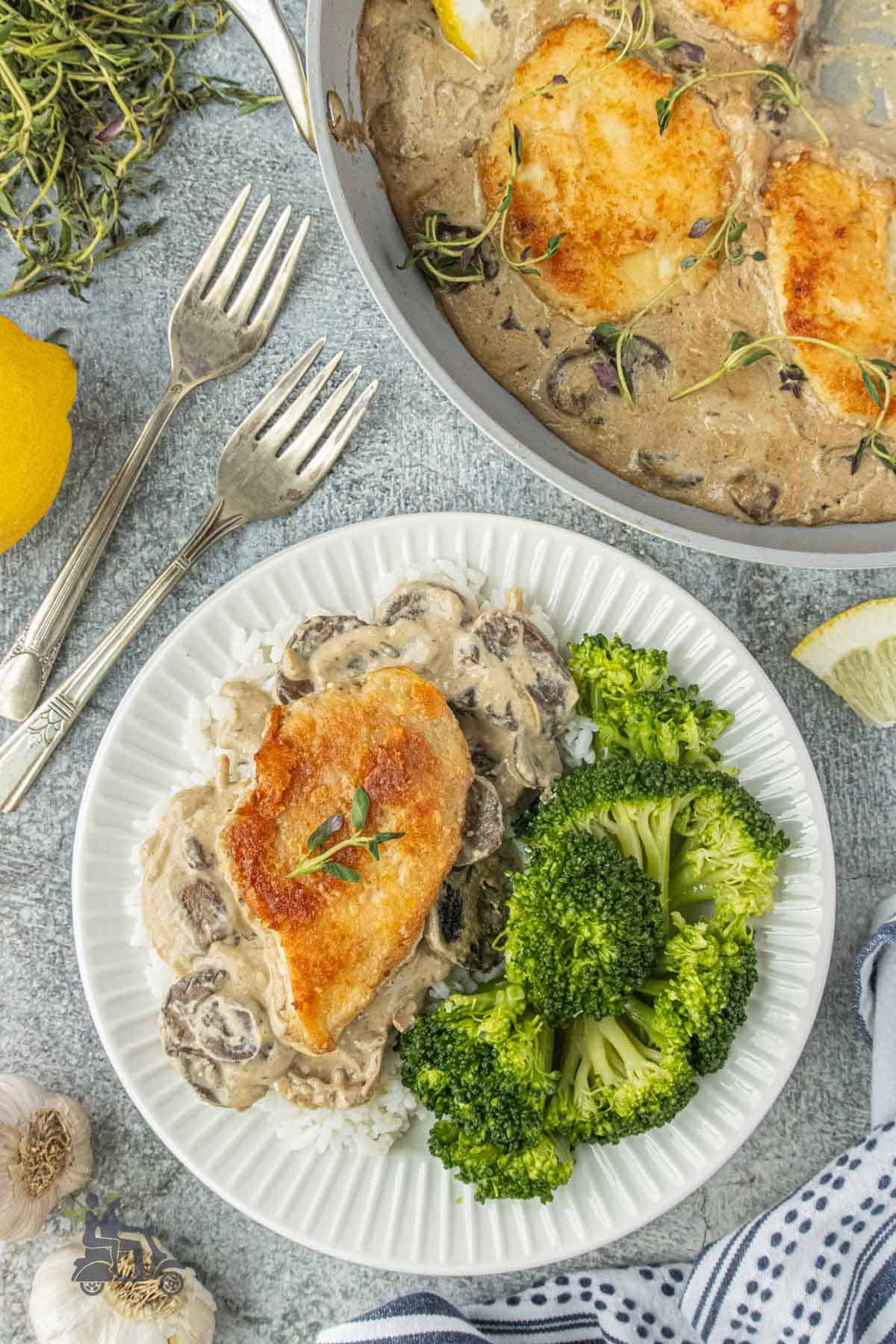 Overhead view of the skillet chicken cutlet over rice with broccoli on the side.