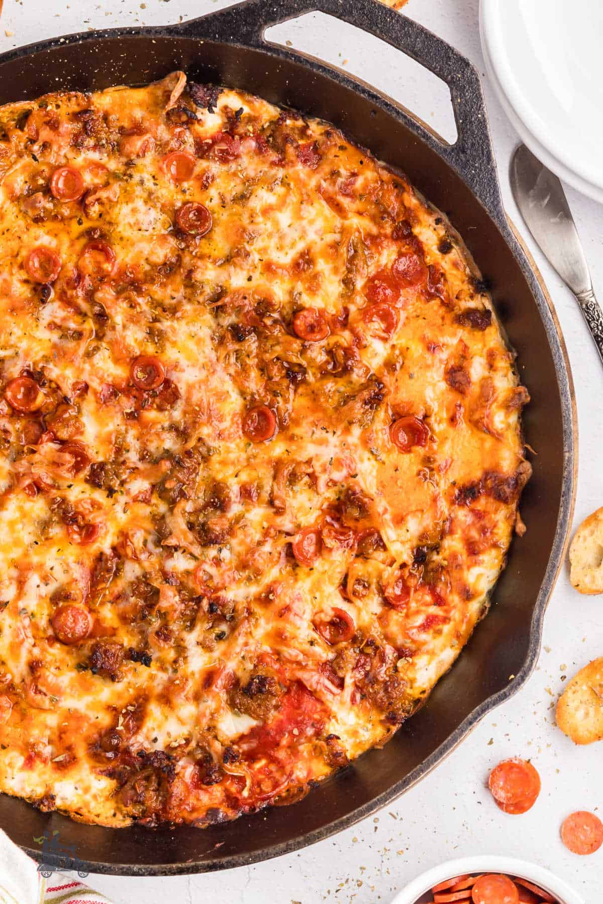 An easy hot appetizer made in a cast iron skillet with cream cheese and pizza ingredients.