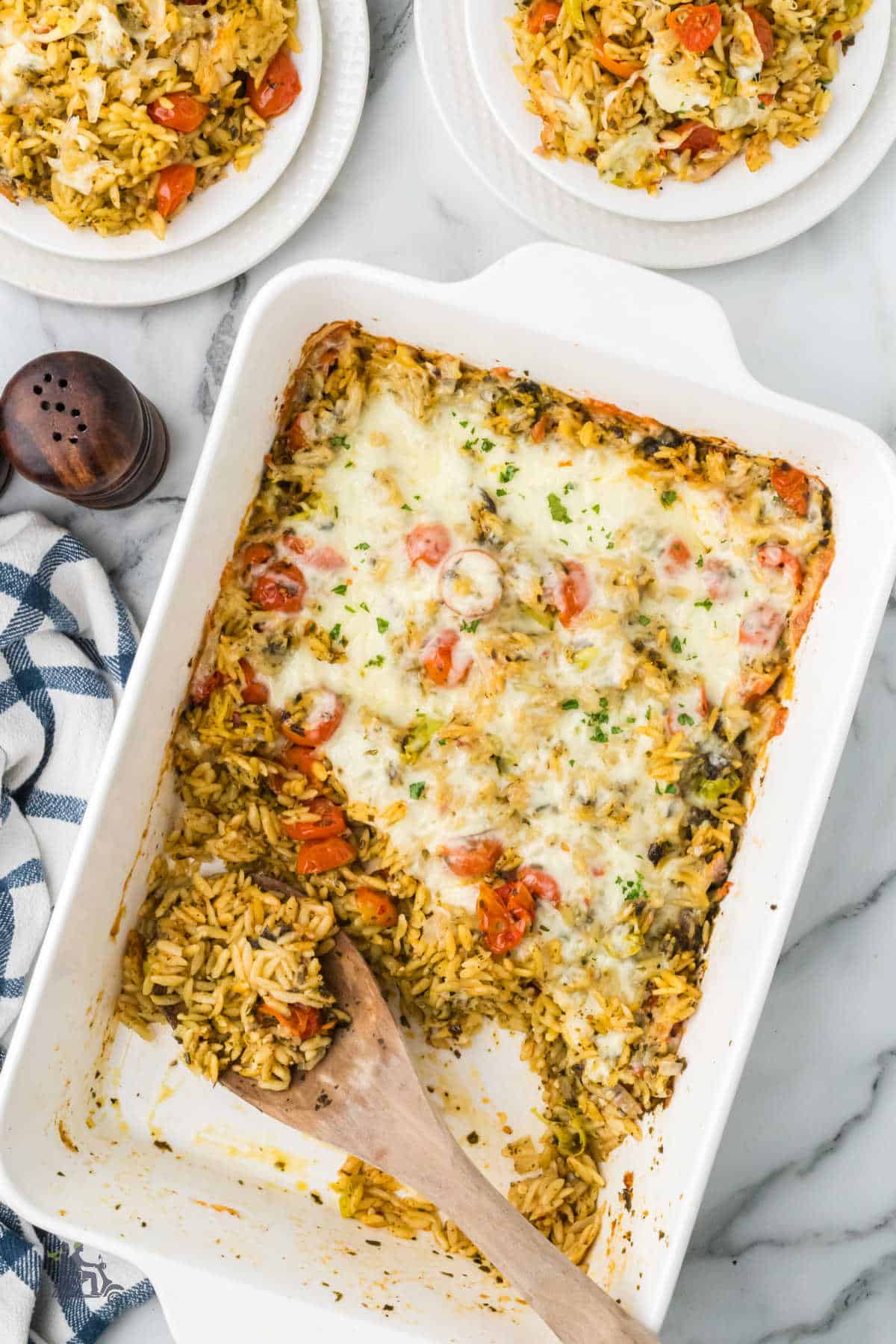 Overhead photo of one-pan pesto orzo bake with roasted tomatoes and melted mozzarella. cheese.