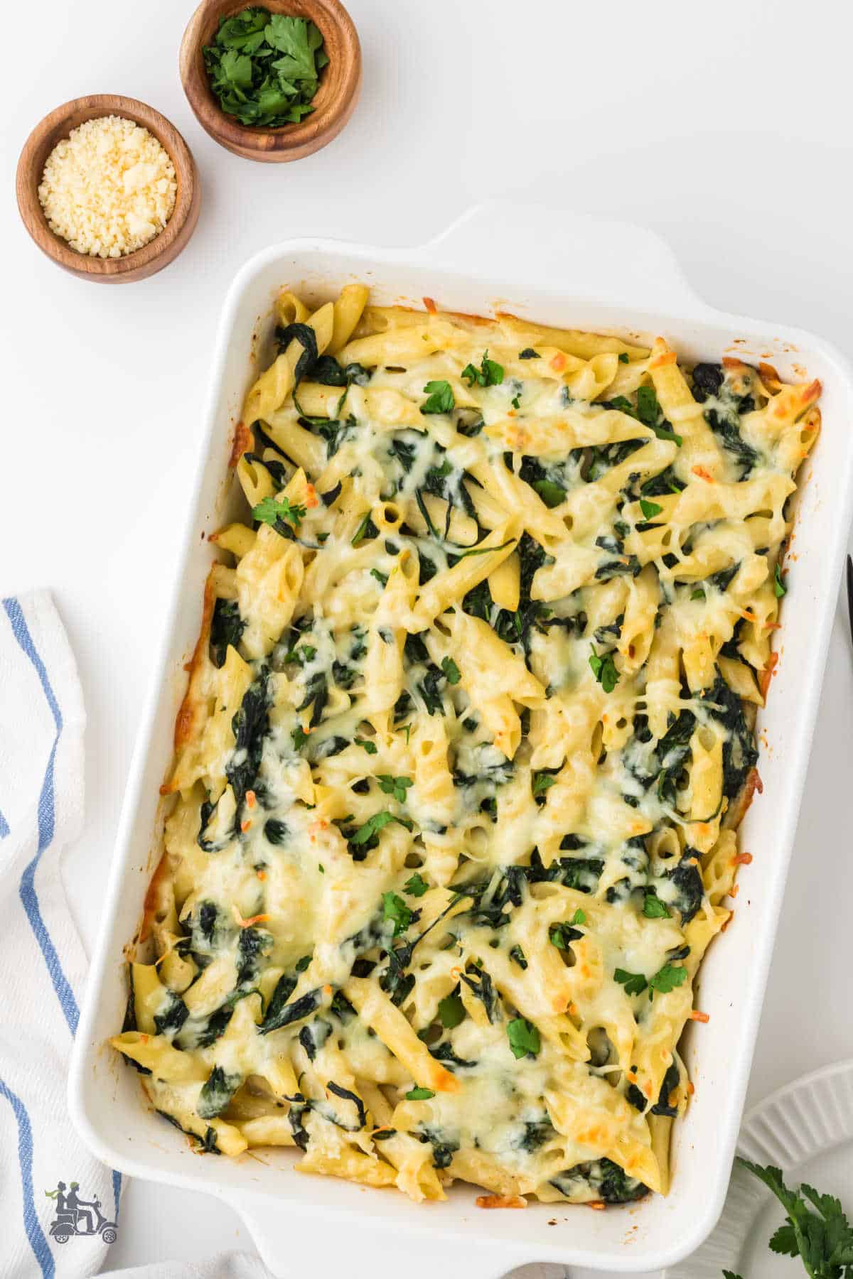 Creamy Spinach Pasta Bake with melted mozzarella cheese in a deep casserole dish. 