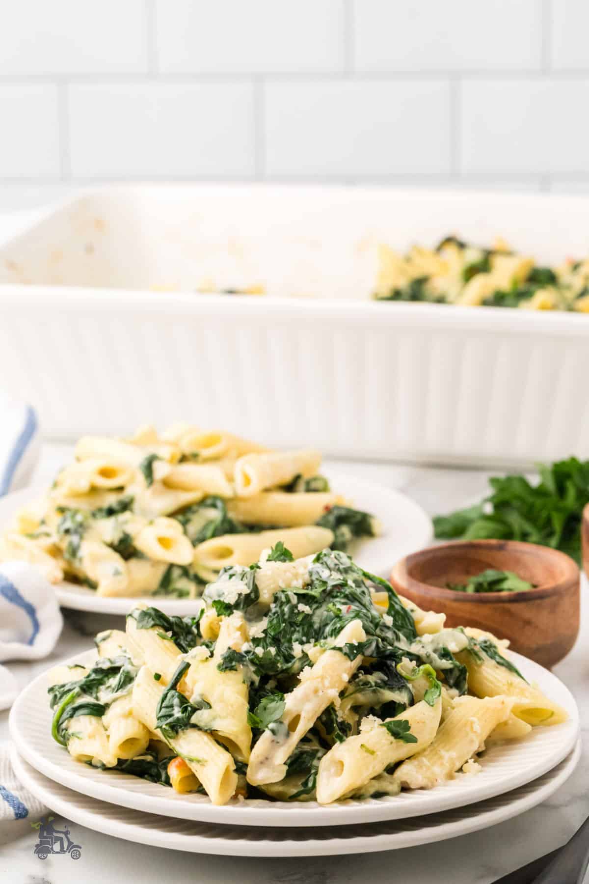A close up of the baked pasta with spinach and cheese on a plate.