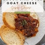 Closeup of creamy goat cheese spread on toasted crostini bread and topped with a savory bacon onion jam.