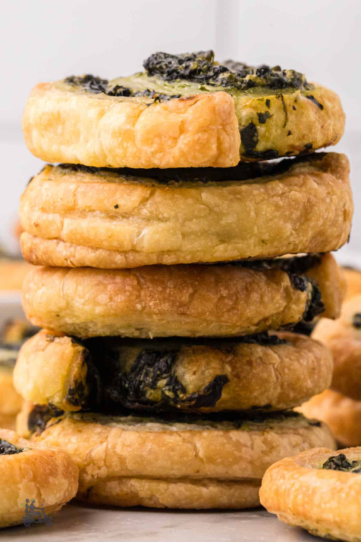 Golden flaky spinach pinwheels served warm for a gathering, party, or snack.