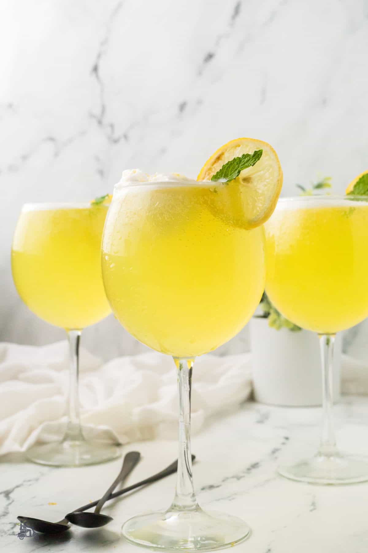 Elegant summer cocktail featuring limoncello and Prosecco served in wine glasses.