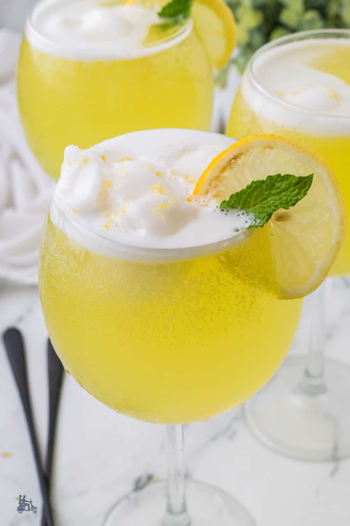 Three glasses filled with creamy lemon sorbet melting on top of Limoncello and prosecco.